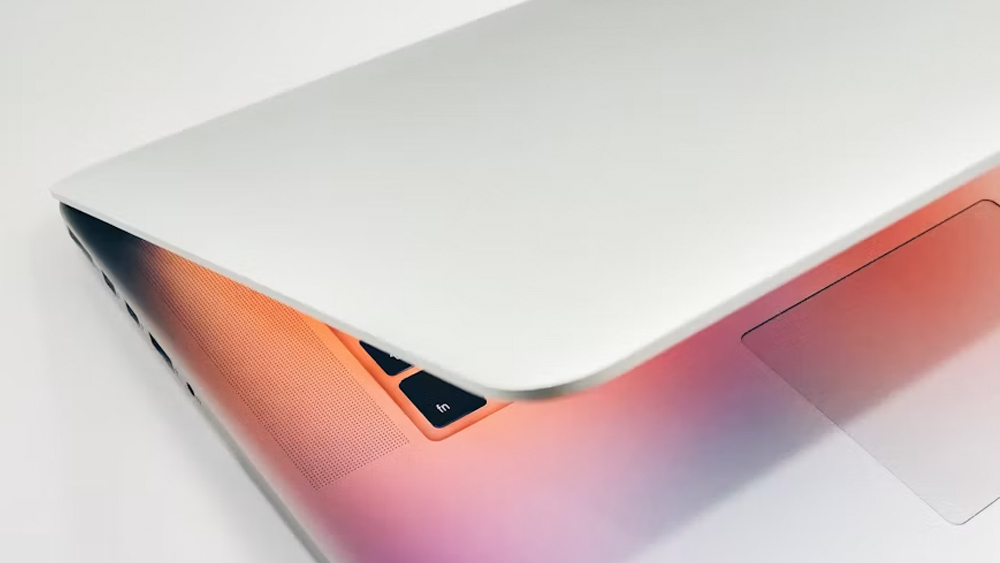 A slightly open laptop with the screenlight shining